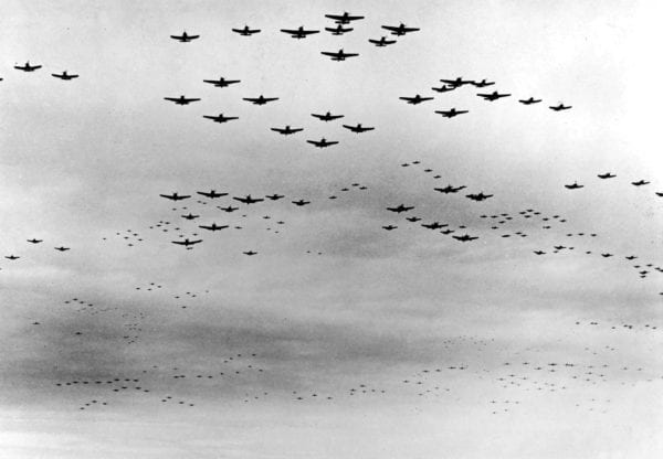 black and white photo of plane in formation over tokyo bay WW2